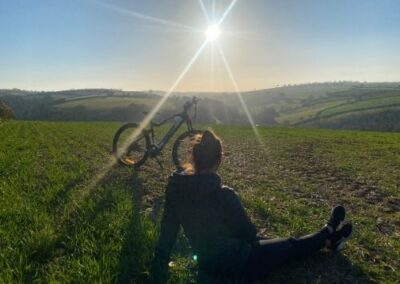 Lady relaxing in sunset with e mountain bike